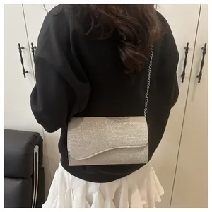 Detail of silver glitter crossbody bag with irregular flap and metal chain strap