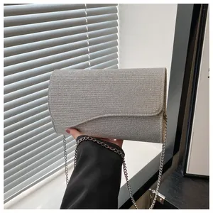 Close-up of the silver glitter texture and asymmetrical wave flap on the evening clutch bag