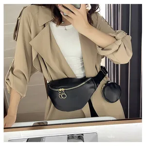 Détail du sac banane en cuir noir avec zips dorés et petit porte-monnaie rond amovible