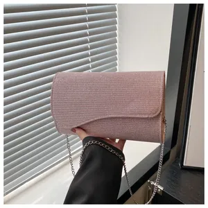 Detail shot of the elegant pink sequined evening bag with a silver chain strap and wavy flap