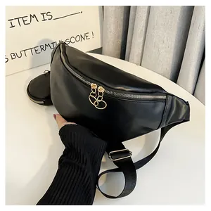 Détail du sac banane en similicuir noir avec petite pochette ronde et fermetures éclair dorées