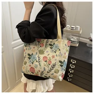 Close-up of retro floral jacquard pattern and woven handles on a canvas tote bag