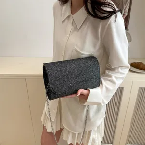 Elegant black sequin evening clutch bag with a slim silver chain strap for women