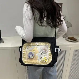 Black canvas ita bag with transparent PVC window showing anime pins and lace details
