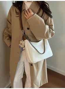 Détail du sac cabas en cuir PU crème avec pendentif ours et bandoulière en chaîne