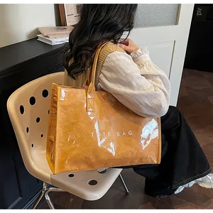 Model showcasing a large ginger yellow tote bag with unique crinkled texture and waterproof film