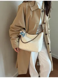 Détail du sac cabas blanc crème avec bandoulière en chaîne et breloque ours en peluche