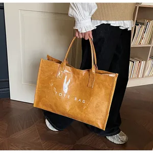 Detail showing high-capacity orange tote bag with crumpled texture and TOTE BAG lettering