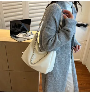 Grand sac cabas blanc avec détail de chaîne en métal dans un décor de bureau décontracté