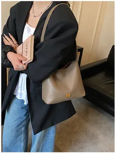 Détail du cuir grainé gris éléphant et du logo doré sur le grand sac cabas chic