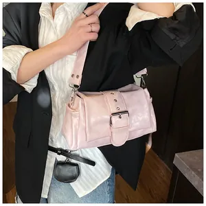Detail of light pink shoulder bag with large silver buckle and rivet decorations