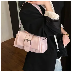 Detail of light pink PU leather shoulder bag with oversized silver buckle and belt strap