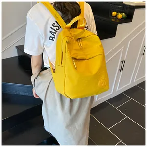 Dettaglio zaino in nylon giallo impermeabile con logo M e tasche con cerniera