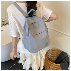 Dettaglio del tessuto impermeabile leggero e delle cerniere di questo zaino blu-grigio