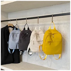 Dettaglio di grandi zaini minimalisti in quattro colori in tessuto di nylon resistente