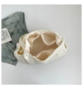 Détail des compartiments intérieurs spacieux et de la doublure dorée du sac cabas en toile