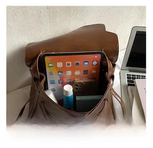 Detail of the large brown leather bag showing spacious interior with tablet and phone