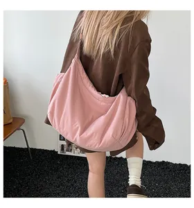 Vue arrière d'un grand sac fourre-tout rose en forme de croissant porté par un mannequin