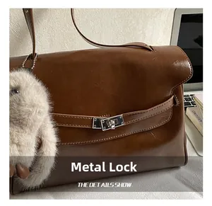 Detail of brown vintage leather handbag with silver lock and plush bunny charm