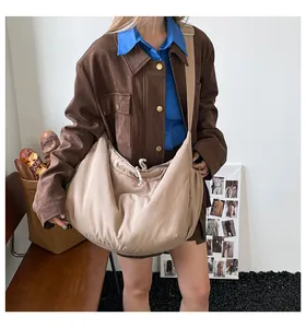 Détail d'un grand sac croissant beige avec bandoulière réglable et tirette à cordon