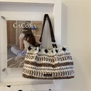 Detail of plush tote bag showing striped faux fur texture and brown leather strap