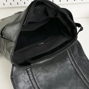 Interior view of black PU leather backpack showing main compartment and zipper pocket