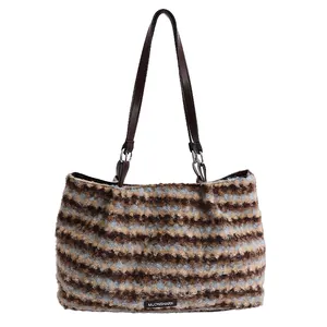 Large striped faux fur tote bag with brown leather handles and curly plush texture