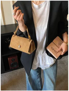 Detail of khaki faux suede handbag featuring a gold twist lock and fine textured finish