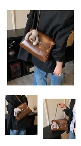 Detail of vintage brown shoulder bag featuring glossy PU leather and plush bunny charm