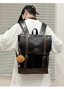 Detail of vintage faux leather backpack in black and brown with teddy bear charm