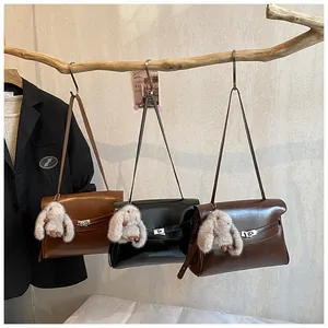 Detailed view of vintage faux leather shoulder bags with plush bunny charms and metal locks