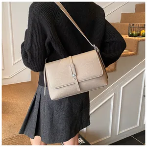 Détail du sac à bandoulière en cuir taupe grainé avec boucle argentée élégante