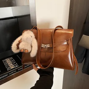 Vintage large brown leather shoulder bag with silver buckle and plush bunny charm