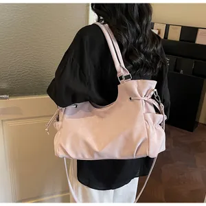Detail view of pinkish-purple shoulder bag showing side drawstring and soft leather texture