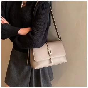 Détail de la texture cuir marron clair et boucle argentée de ce sac à bandoulière élégant