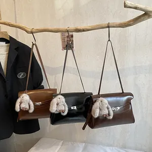 Retro high-capacity leather shoulder bag with bunny pendant in brown, black, and coffee