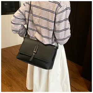 Vue détaillée du sac bandoulière noir montrant sa texture grainée et sa boucle argentée