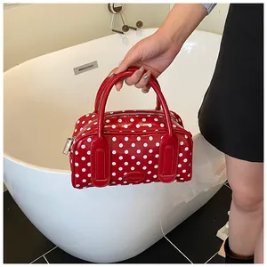 Detailed close-up of a red polka dot handbag with dual handles and BOBOOM logo plaque