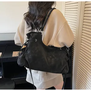 Close-up of black suede tote bag featuring a soft texture and long shoulder straps