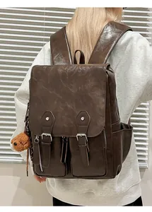 Detailansicht eines dunkelbraunen Kunstlederrucksacks mit Vintage Schnallen und Taschen