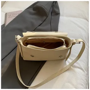 Sac à bandoulière crème minimaliste en texture grainée litchi pour la collection printemps
