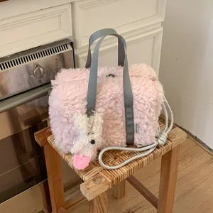 Pink plush tote bag with grey handles and cute white dog pendant on a wooden stool