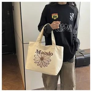 Detail of embroidered daisy and Maodo lettering on vintage canvas tote bag