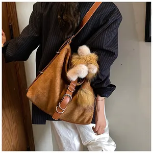 Close-up of brown woven leather tote with intricate Intrecciato texture and plush charm