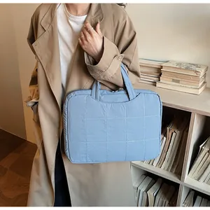 Detail shot of a light blue quilted tablet handbag with stitching in a library setting
