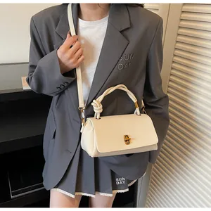 Close-up of cream lychee texture handbag featuring retro gold twist lock and knotted handle
