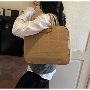 Close-up of khaki quilted tote bag with square stitch pattern for daily commuting