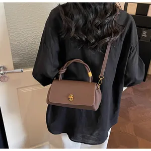 Rear view of brown lychee leather handbag with golden twist lock and knot handle