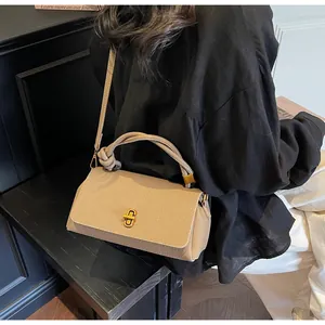 Detail of beige lychee pattern leather handbag with knotted handle and gold twist lock