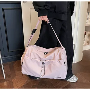 Detailaufnahme der rosa Fitnesstasche mit Kordelzugtasche vorne und Markenlogo-Druck